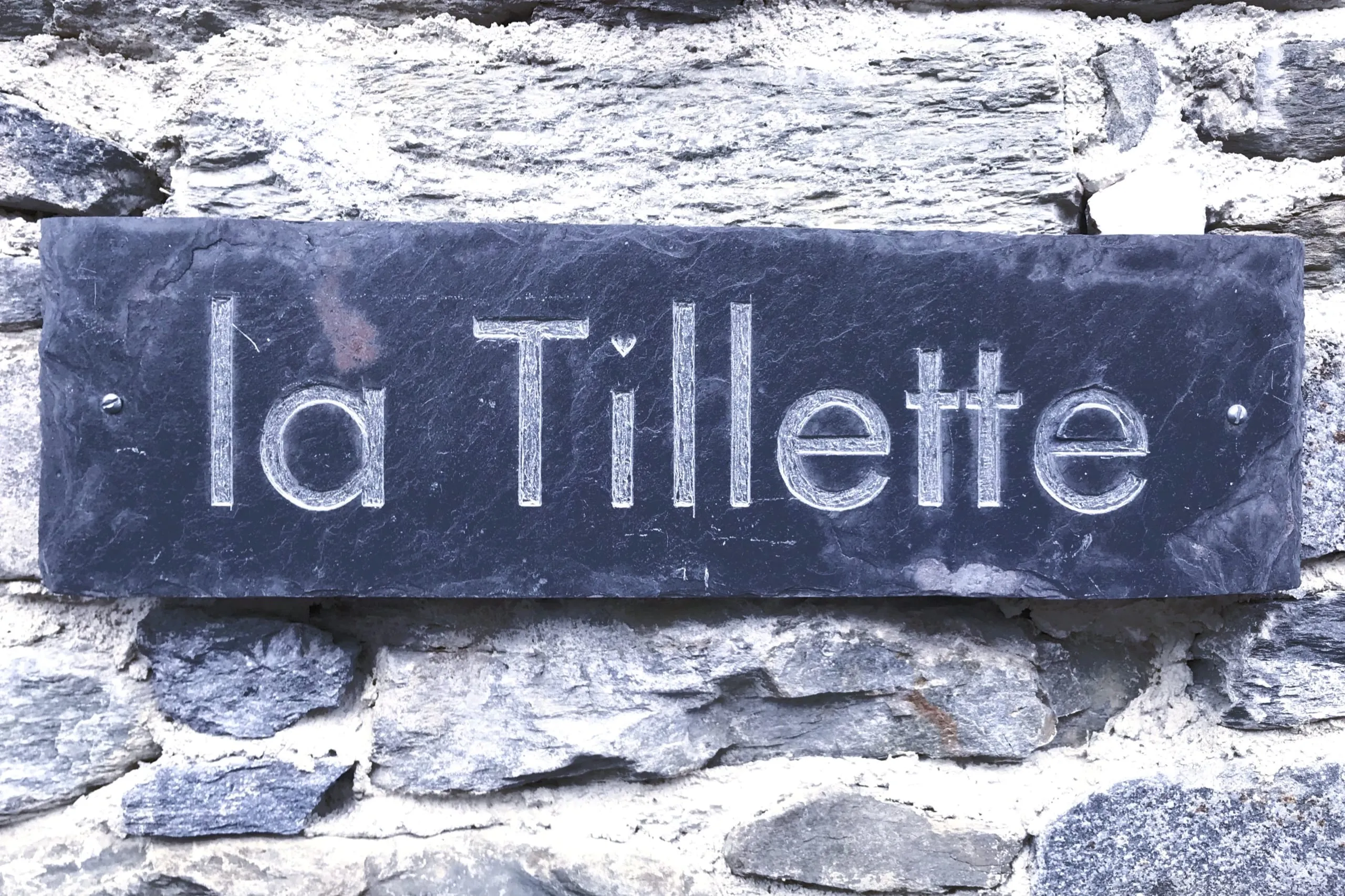 La plaque en ardoise faite main portant le nom du chalet