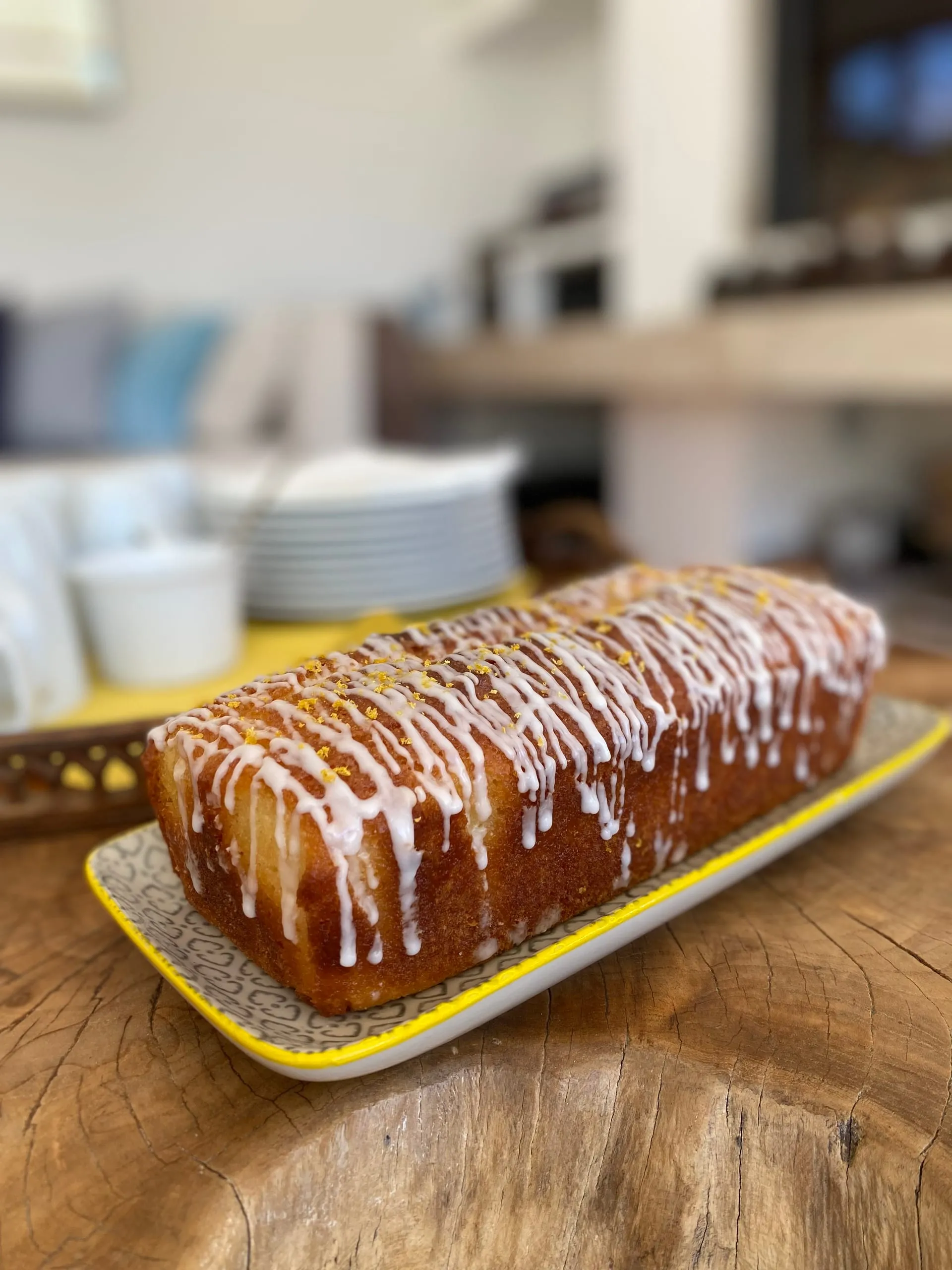 Un cake au citron glacé et parsemé de zestes, posé sur un plat dans le chalet