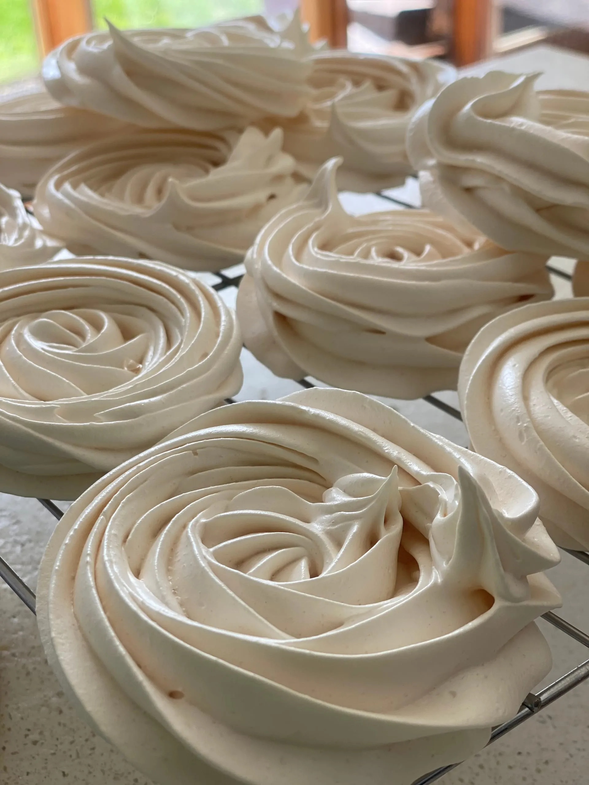 Des meringues dressées à la poche, en train de refroidir sur une grille