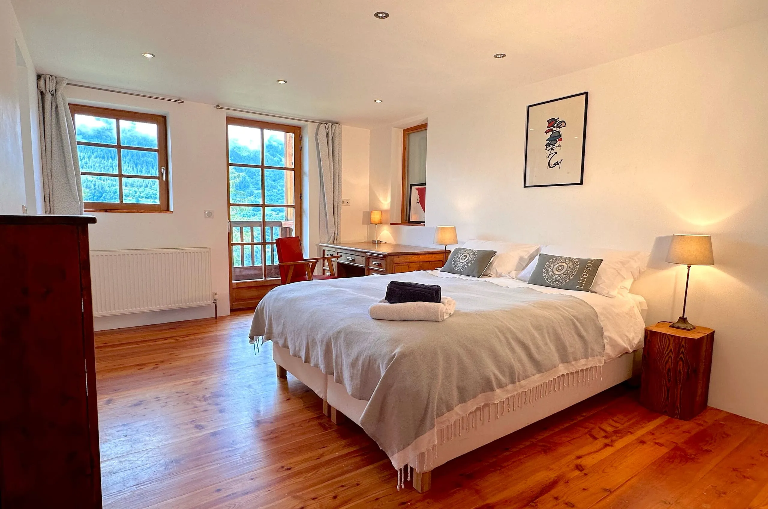La chambre un, grand lit, bureau et deux fenêtres donnant sur la montagne