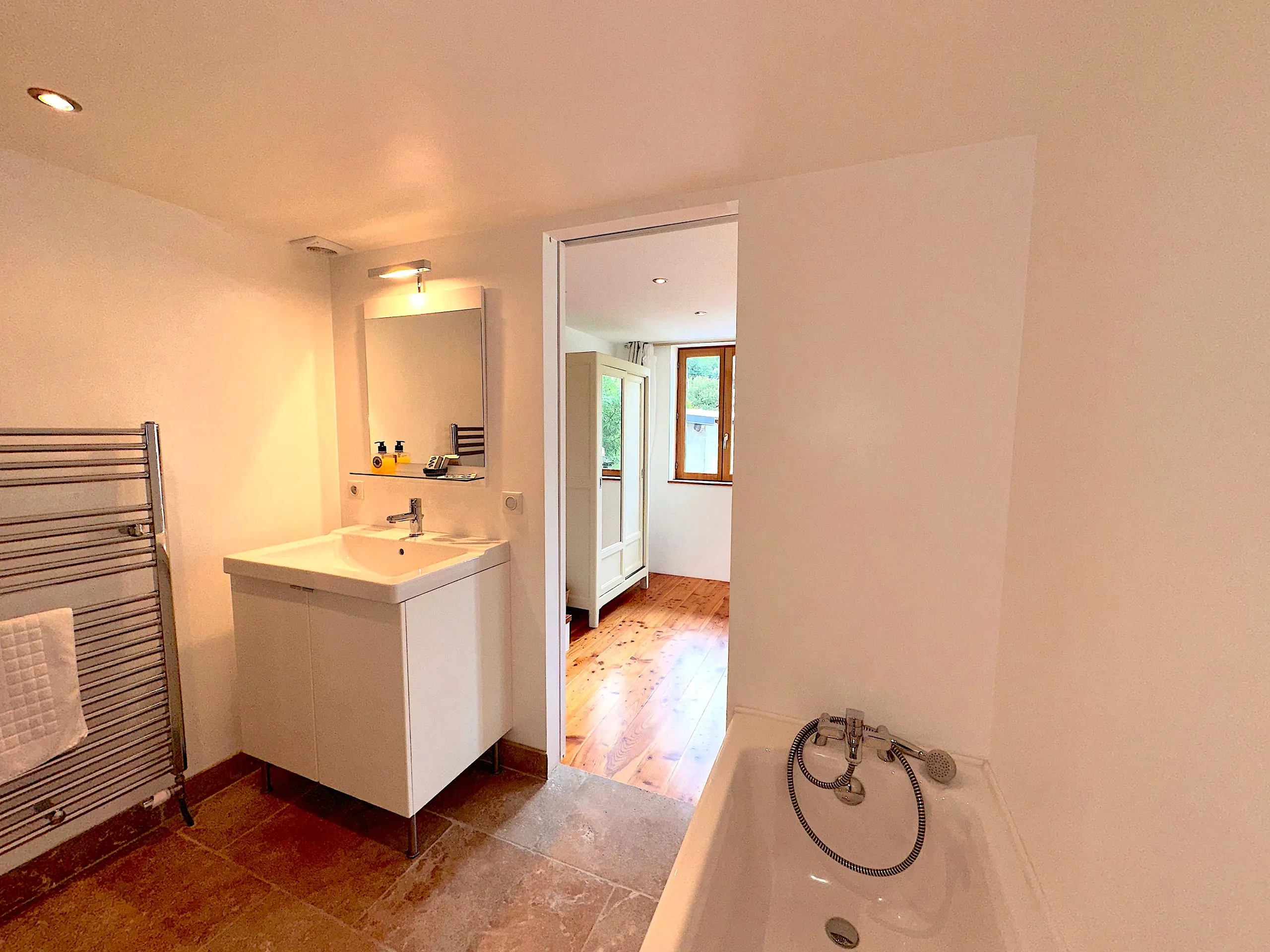 La salle de bain de la chambre deux, avec baignoire et sèche-serviettes