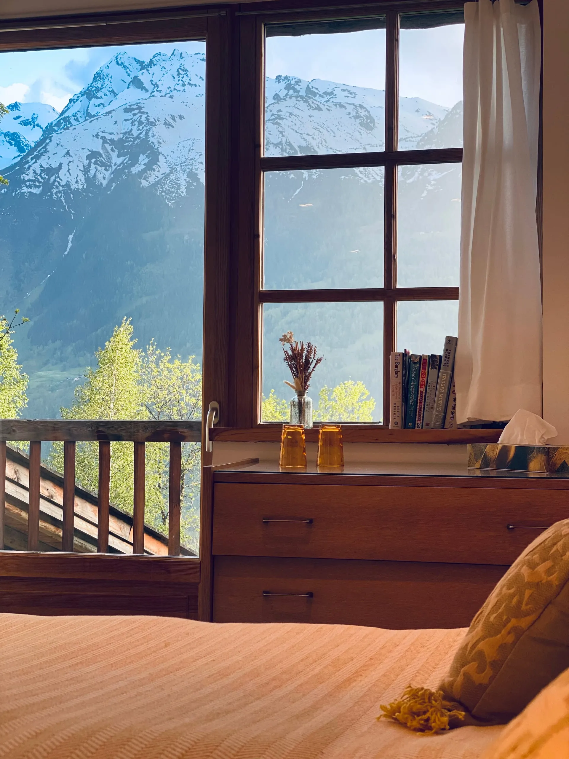 La vue depuis le lit de la chambre deux, par-dessus le balcon jusqu’aux montagnes d’en face