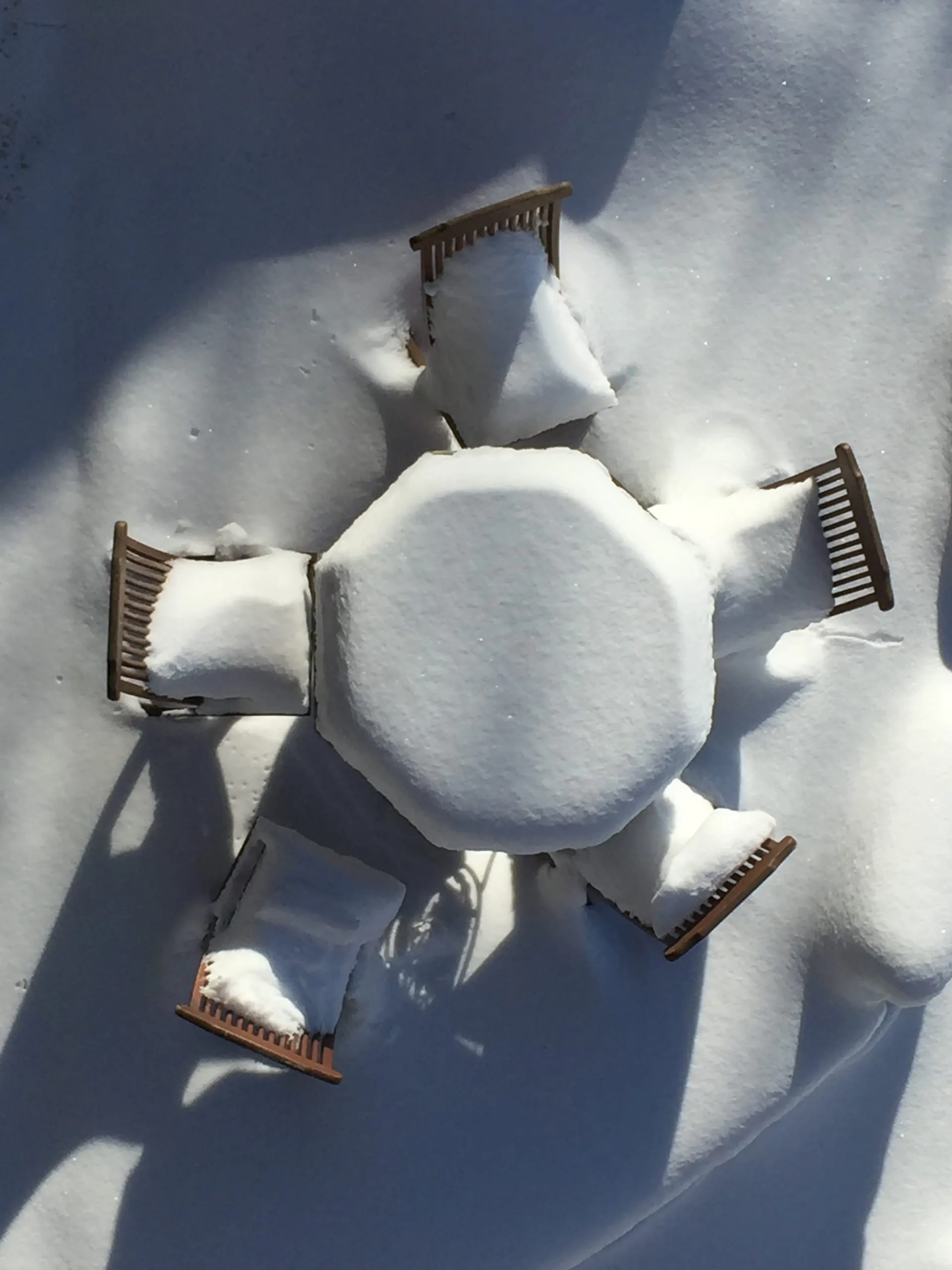 Une table et des chaises sur la terrasse, ensevelies sous la neige